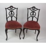 A pair of Edwardian ebonised Adams style Side Chairs, with decorative pierced and carved backs,