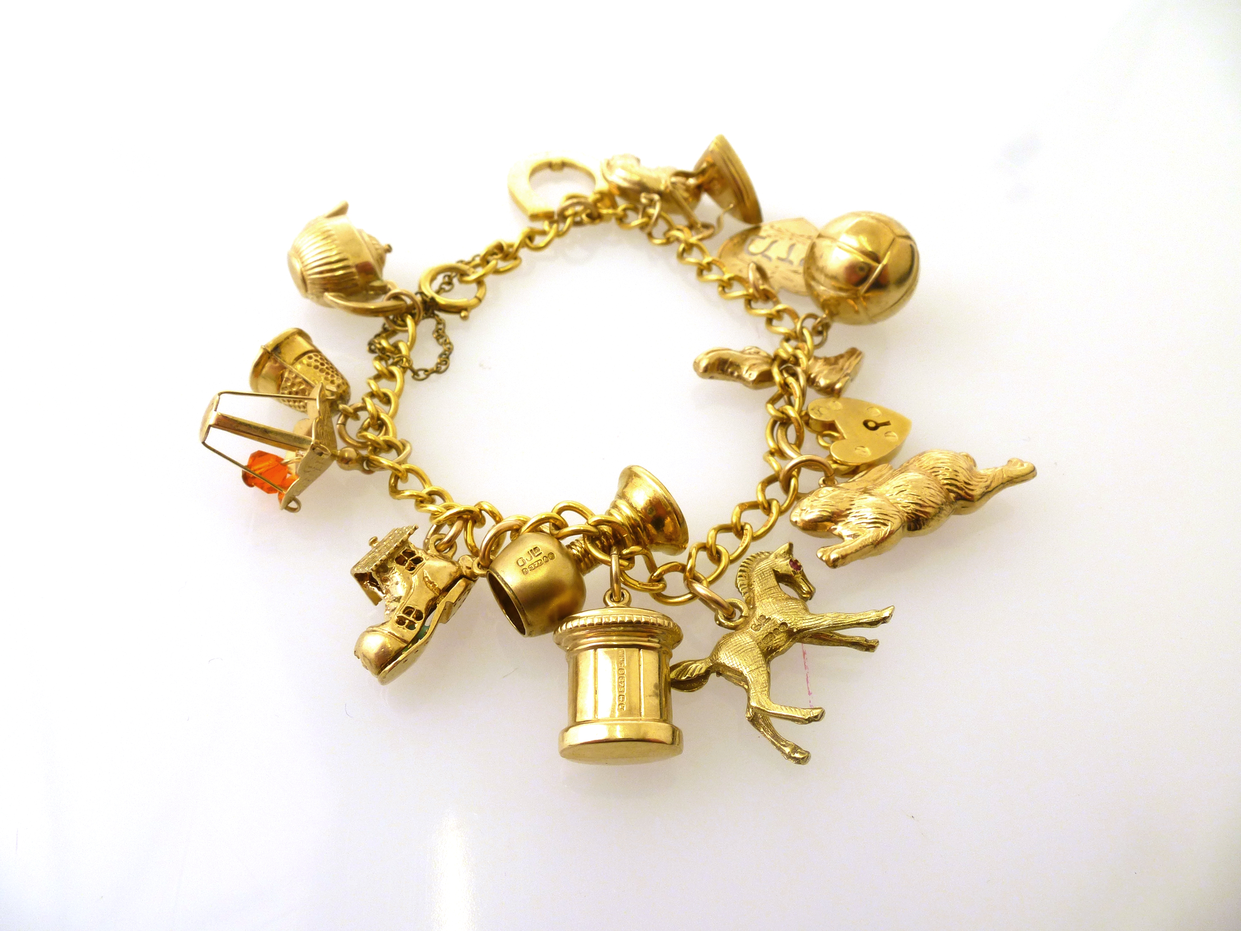 9K GOLD CHARM BRACELET WITH 15 9K GOLD CHARMS AND A 9K GOLD SAFETY CHAIN. 26G