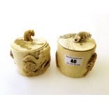 2 CARVED IVORY POTS – DECORATED WITH LIONS AND LIONS AND ELEPHANTS H: APPROX 2.75”