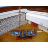 BLUE AND WHITE MODEL BOAT ON STAND