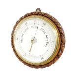 Oak circular wall barometer, the 10" white dial within a rope twist carved surround