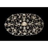 Attractive oval openwork scroll diamond brooch, rub-over set in white metal, the principle oval