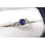 18k white gold sapphire and diamond ring, the oval sapphire with a surround of eight marquise shaped