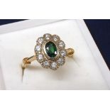 14k oval green garnet and diamond cluster ring, the oval emerald in a surround of ten round