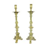 Pair of 19th century tall brass candlesticks with baluster and shelved columns upon tri-form