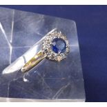18ct and platinum sapphire and diamond cluster ring, the sapphire 0.50ct approx in a surround of