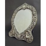 Late Victorian silver mounted heart shaped easel mirror, the pierced repousse surround depicting