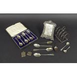 Assorted silver items to include a four section lancet toast rack, embossed Art Nouveau silver