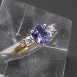 18ct tanzanite and diamond three stone ring, the oval tanzanite 1.28ct approx, flanked with two