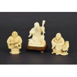 Japanese ivory netsuke modelled as an elderly man holding a staff, upon a hardwood base, 2.5"