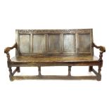 17th century oak settle, the cresting rail carved with stylised foliage and the initials I G,