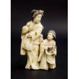 Japanese ivory okimono of a mother and child, standing in typical dress with the daughter riding a