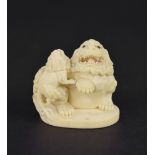 Japanese carved ivory, modelled with mystical beasts upon an oval base, 2" high