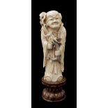 Japanese ivory okimono, finely carved and modelled as a sage holding a smoke-blowing dragon, fixed