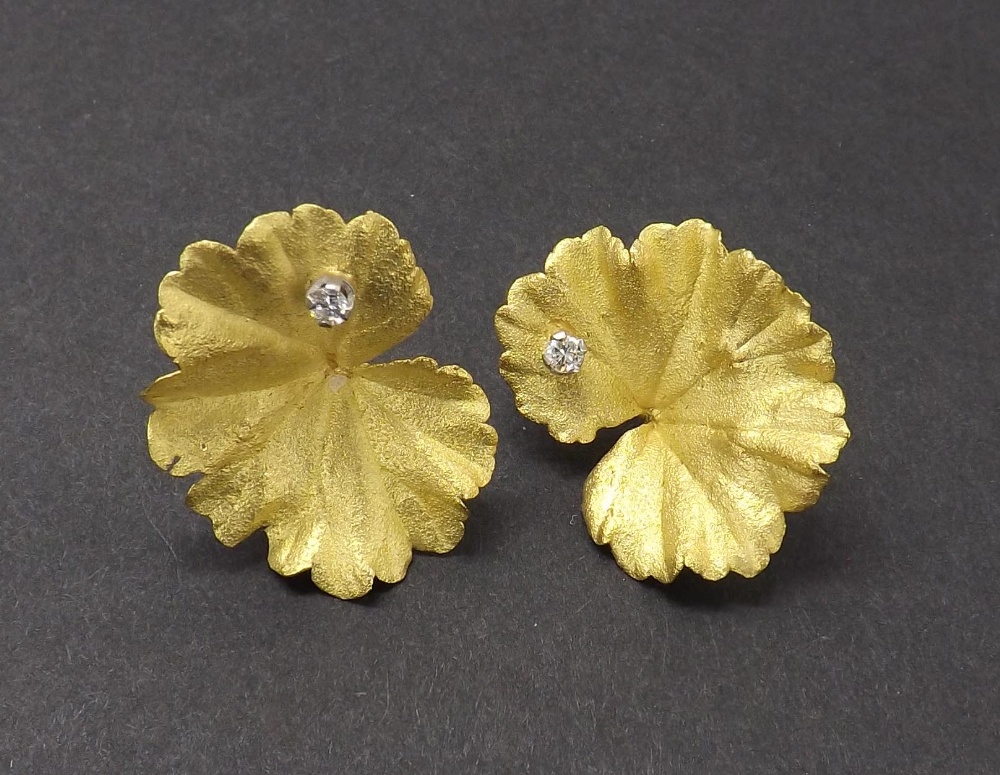 Pair of 18ct Andrew Grima leaf shaped earrings, each set with a single small round diamond and