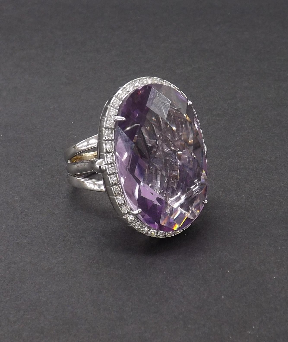 Fiorelli 18ct white gold large cocktail ring, the oval facet cut amethyst within a surround of round