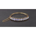 Antique gold diamond set hinged bangle set with fourteen opal cabochons, with safety chain, 9.6gm,