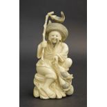 Japanese ivory okimono modelled as seated fisherman holding his catch on a naturalistic carved base,