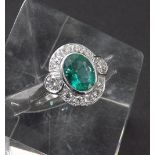 18ct white gold oval cluster ring, the central emerald estimated 1.5ct approx in a surround of round