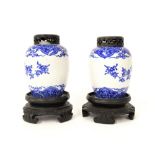 Pair of Chinese blue and white baluster jars, upon pierced wooden stands and lids, 8.5" high