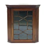 Early 19th century mahogany hanging corner display cabinet, the moulded cornice over a single