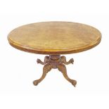 Victorian figured walnut loo table, the oval tilt-top on turned baluster column and four carved