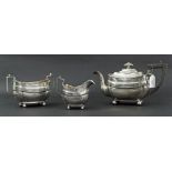 George III three piece silver tea service of squared boat shaped form, engraved with a family Crest,