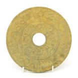 Circular stoneware circular Bi disc, decorated in relief with archaic designs, 6.25" diameter