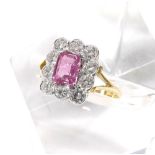 Attractive 18ct pink sapphire and diamond cluster ring, the emerald-cut sapphire in a surround of