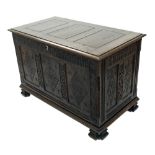 Antique carved oak triple panelled coffer with carved decoration, the hinged cover enclosing an open