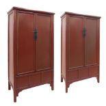 Pair of Chinese red lacquered wardrobes of tapering form, one with hanging rail interior and the