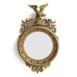 Regency gilt and gesso circular convex wall mirror surmounted by an eagle, 23.5" wide, 41" high,