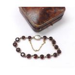 Attractive gold garnet set bracelet with an oval mother of pearl set clasp, with safety chain, 9.