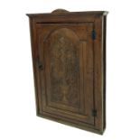 Georgian oak corner cupboard with carved Renaissance vase and chrysanthemum decoration to the door