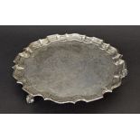 Late 19th century silver salver, with a piecrust border and engraved foliate cartouche upon three