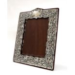Good large Edwardian silver photograph frame, ornate pierced and repousse foliate surround on a