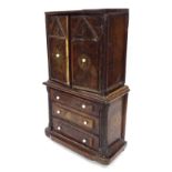 Antique apprentice walnut cabinet on chest, the plain top over two panelled cupboard doors enclosing