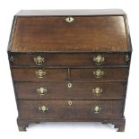 18th century oak bureau, the green leather lined fall-front top enclosing a fitted interior and well