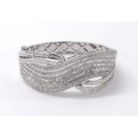 Impressive 18k diamond set hinged bangle, with a swirl crossover design st with baguette and