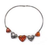 Modernist silver and amber necklet, applied with five graduated heart links, three set with amber,