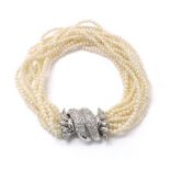 Attractive eleven strand seed pearl bracelet, with a fancy white metal clasp pavé set with round