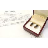 Pair of 18ct gold studs of tapering oval shape, each set with a cabouchon cut ruby within a black