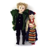 Two Continental bisque-headed dolls, the taller dressed in a green felt coat, suede waistcoat and