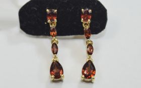 Mozambique Red Garnet Drop Earrings, a pear cut below two smaller marquise cuts, suspended from a