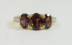 Mozambique Red Garnet Three Stone Ring, the centre oval cut stone of 1.