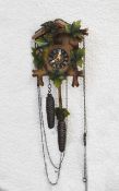 Small Wooden Cuckoo Clock Black Forest clock with traditional wooden foliage design and white dial.