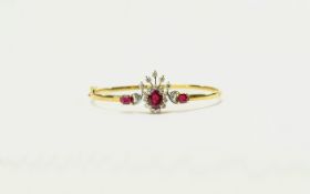 18ct Gold Hinged Bangle set with three rubies, surrounded by round brilliant cut diamonds.