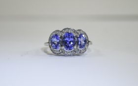 Tanzanite and Diamond Trilogy Ring, three oval cut tanzanites, of excellent colour,