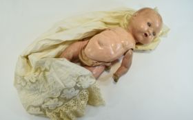 German Bisque Headed Doll with blue moving eyes, red lips and jointed arms and legs.
