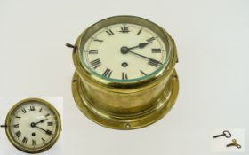 A Vintage English Heavy Circular Brass Ships Clock. Cream Dial with Black Roman Numerals.